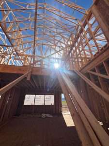 Live Construction Updates - interior framing photo with sun burst coming through walls.